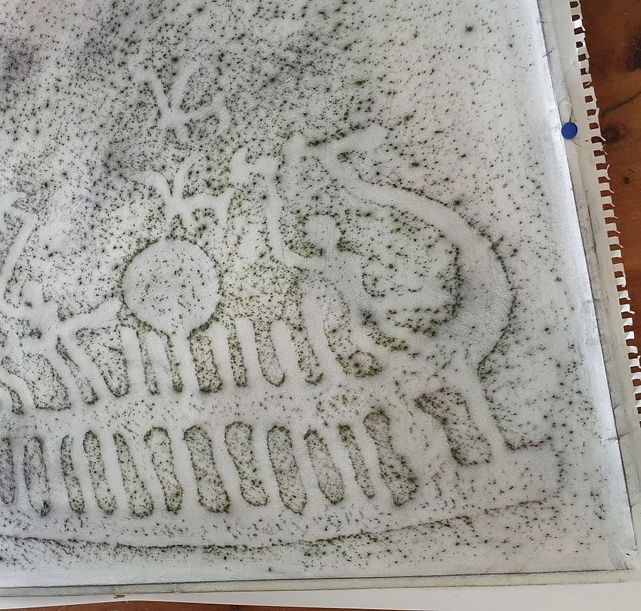 Ein Steinrelief wird mit Hilfe der Frottage-Technik auf Papier übertragen. Es ist eine Schiffsdarstellung zu erkennen. 