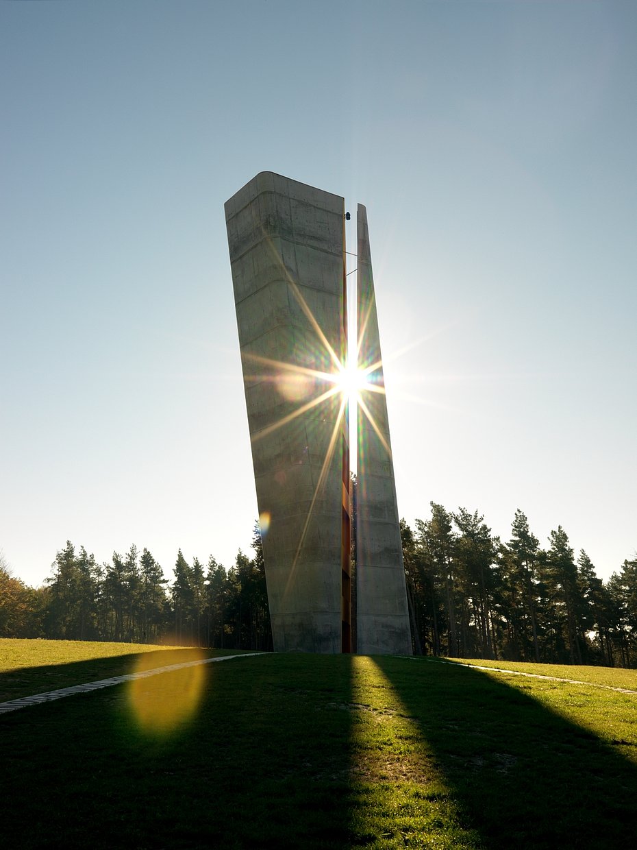 Moderne Architektur in Form eines Turms mit Spalt, in dem der Sonnenuntergang zu beobachten istist